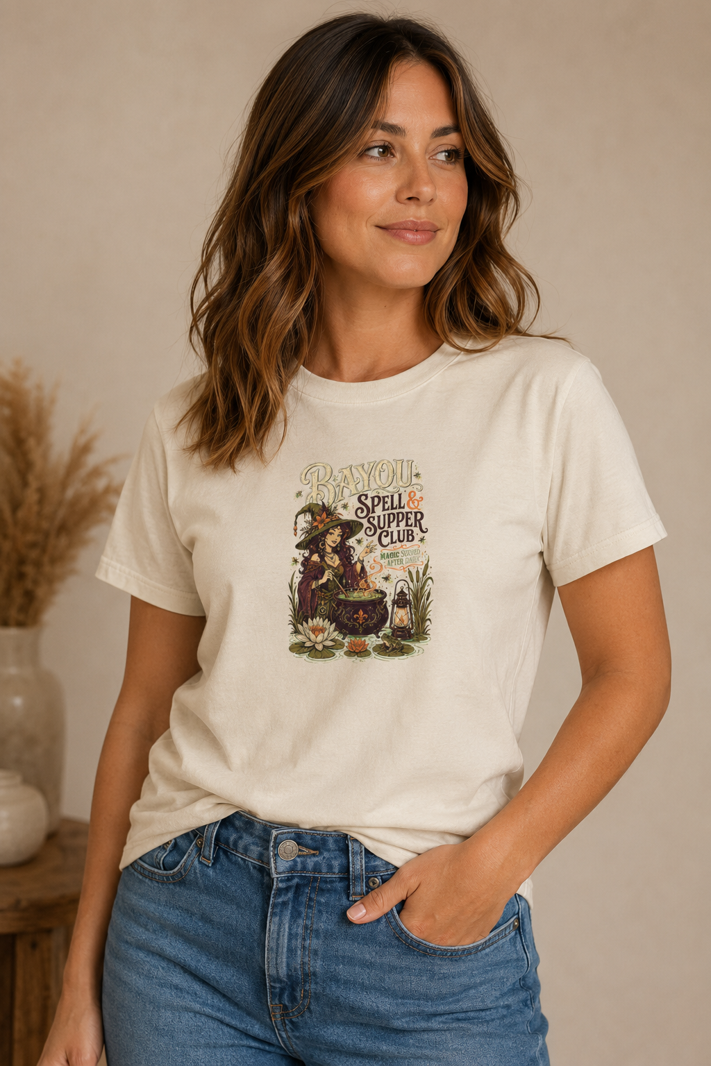 Woman wearing a beige Bayou Spell & Supper Club graphic T-shirt