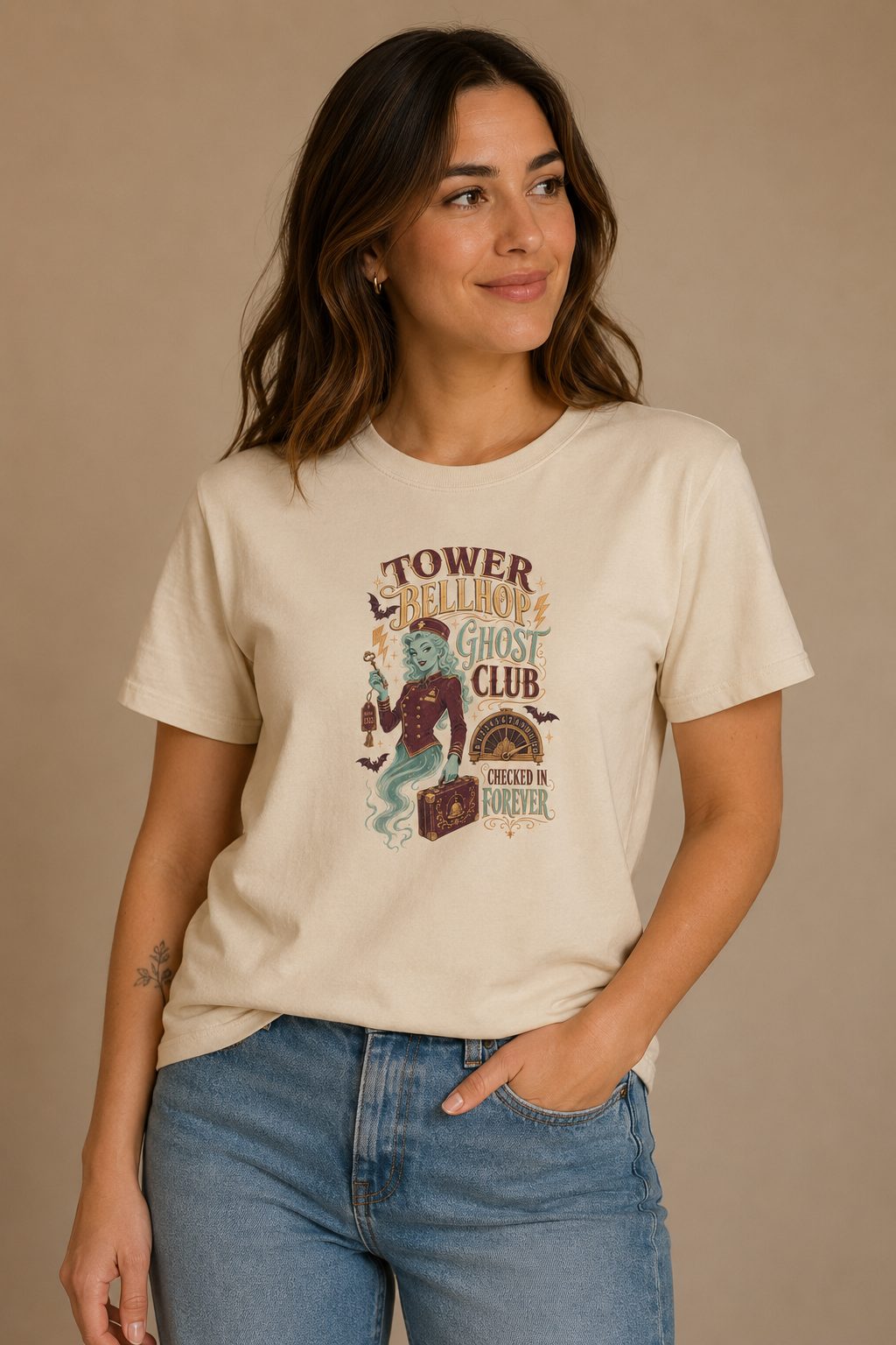 Woman wearing a beige Tower Bellhop Ghost Club graphic T-shirt