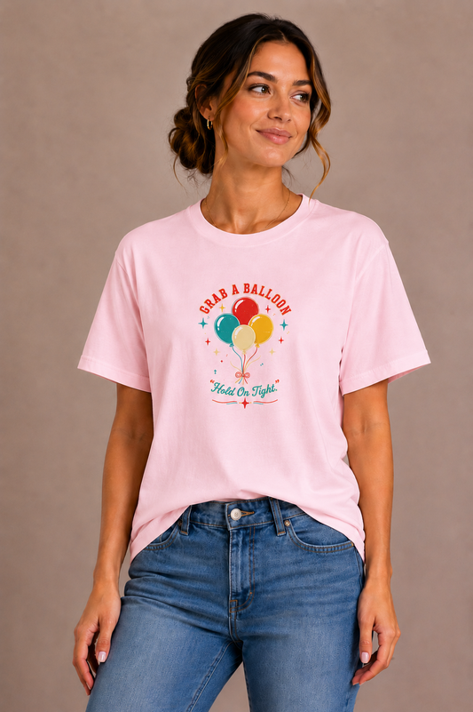 Woman wearing a pink crew-neck t-shirt with the 'Grab a Balloon' retro balloon bunch design printed on the chest