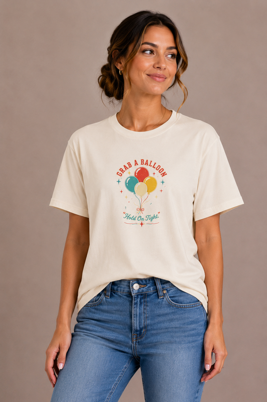 Woman wearing a sand crew-neck t-shirt with the 'Grab a Balloon' retro balloon bunch design printed on the chest