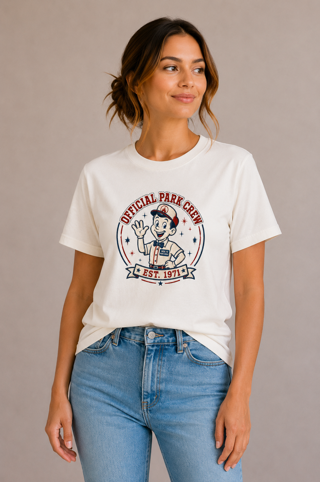 Woman wearing a sand crew-neck t-shirt with the 'Official Park Crew Est. 1971' mascot badge design printed on the chest
