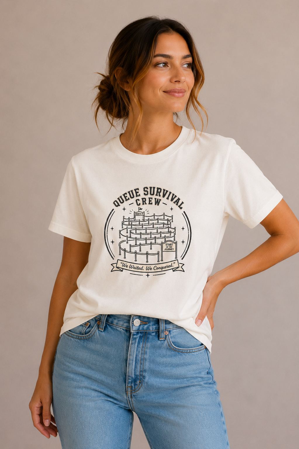 Woman wearing a sand crew-neck t-shirt with the 'Queue Survival Crew – We Waited, We Conquered' queue-line badge design printed on the chest