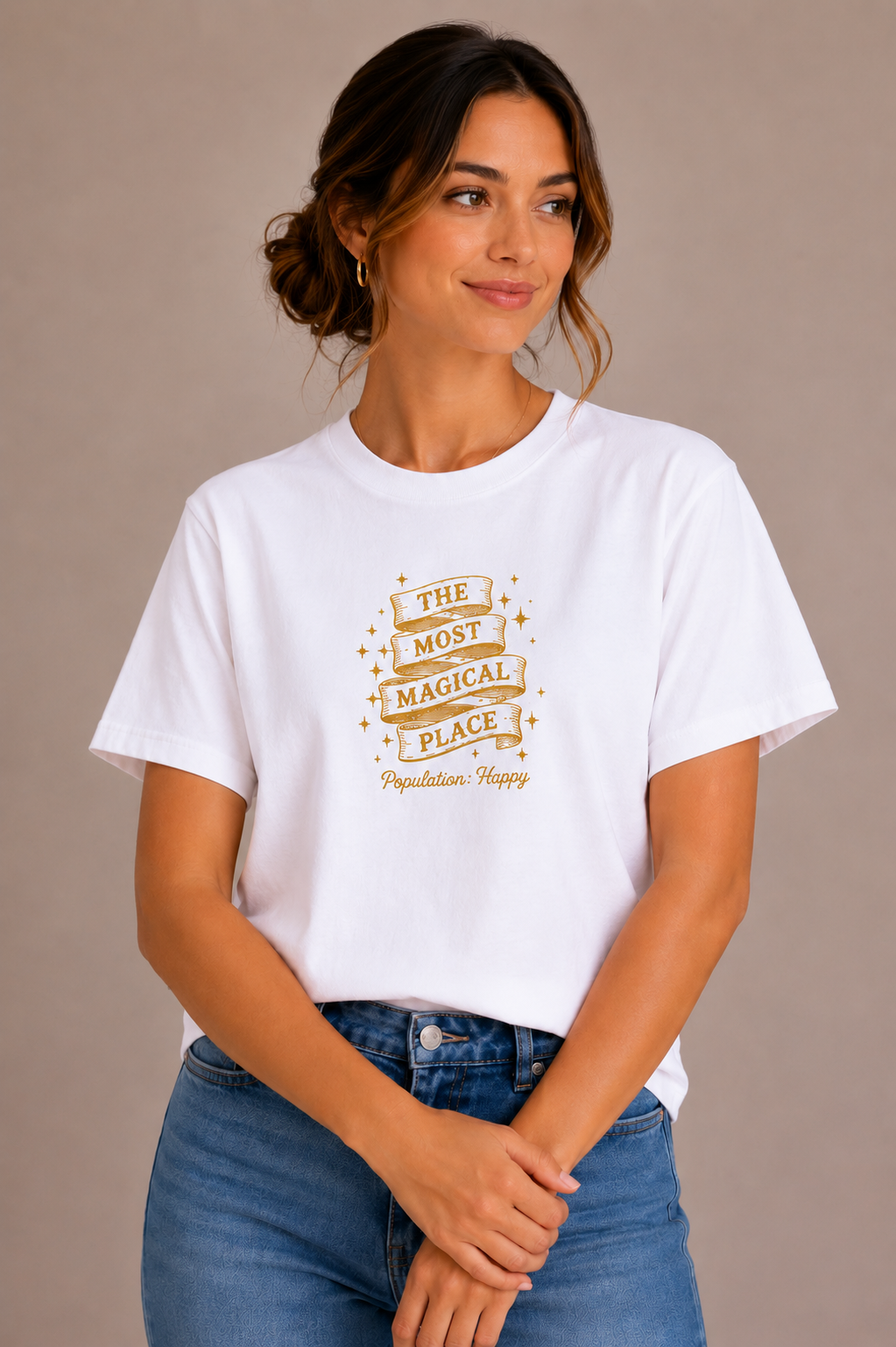 Woman wearing a white crew-neck t-shirt with the 'The Most Magical Place – Population: Happy' ribbon banner design printed on the chest
